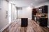 Modern kitchen with sleek granite countertops, stainless steel appliances, and elegant wood flooring.