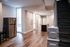 Inviting open-concept apartment with sleek hardwood floors, modern stainless steel appliances, and elegant staircase for an upscale living experience.