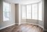 Bright corner room featuring elegant hardwood flooring and large windows with abundant natural light.