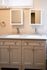 Elegant bathroom with modern dual sinks and sleek cabinetry under natural lighting.