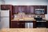 Modern kitchen with sleek stainless steel appliances, granite countertops, and rich dark wood cabinetry.