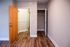 Inviting hallway entrance with warm wood flooring and a convenient closet, perfect for storage and style.
