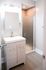 Modern bathroom with sleek vanity, stylish lighting, and a frosted glass shower door, offering a serene and contemporary feel.