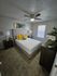 Cozy bedroom featuring a plush bed with vibrant yellow cushions, elegant side tables, and modern decor accents, exuding warmth and comfort.