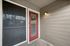 Inviting apartment entrance with a stylish red door and elegant porch lighting, perfect for cozy evenings.