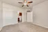 Bright bedroom with plush carpet, ceiling fan, and en-suite bathroom featuring modern fixtures.