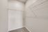 Spacious and bright walk-in closet with sleek wire shelving, perfect for organizing your wardrobe.