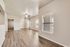 Bright and inviting living space featuring gleaming hardwood floors, large windows with abundant natural light, and modern ceiling fan.