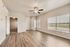 Bright and airy living space with elegant hardwood floors, large window views, and modern ceiling fan, leading into a cozy adjacent room.