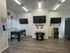 Modern gaming room featuring sleek foosball table, classic arcade machine, and dual wall-mounted TVs with vibrant neon accents.