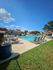 Inviting outdoor swimming pool with sun loungers on a sunny day, surrounded by modern residential buildings.