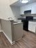 Modern kitchen with sleek granite countertops, elegant cabinetry, and contemporary appliances on rich wooden flooring.