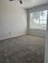 Bright and cozy bedroom with plush carpeting and a large window offering scenic views.