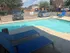 Inviting outdoor pool area with comfortable blue loungers, perfect for relaxation and soaking up the sun.