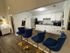 Stylish kitchen with modern white cabinets, granite countertops, and elegant blue bar stools; ideal for entertaining and culinary creativity.