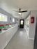 Modern laundry room with multiple washing machines and dryers, featuring sleek appliances and ample natural light.