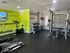 Bright, motivational fitness room with modern exercise equipment and inspiring wall quotes.