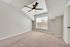 Bright and airy bedroom with plush carpet, large window for natural light, and modern ceiling fan, perfect for relaxation.