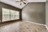 Inviting room with vaulted ceiling, large windows flooding natural light on elegant wood flooring.