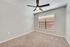 Bright, spacious bedroom with a modern ceiling fan and plush carpet, offering a tranquil retreat with natural light streaming through the large window.