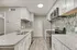 Modern kitchen with granite countertops, stainless steel appliances, and mosaic tile backsplash.