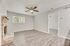 Bright and modern living room with sleek wooden flooring, brick fireplace, and ceiling fan, perfect for relaxing and entertaining.