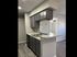 Modern kitchen with sleek gray cabinetry, textured walls, and elegant gray countertops, enhancing the stylish ambiance.