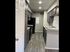Modern kitchen with sleek grey cabinets, stainless steel appliances, and elegant wood flooring, showcasing a stylish and contemporary design.