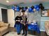 Cheerful apartment lounge featuring a festive blue and silver balloon display, vibrant snack table, and cozy seating area.