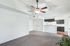 Bright and modern living space featuring plush carpet, an elegant ceiling fan, and an inviting open-concept kitchen with sleek cabinetry.