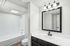 Bright and modern bathroom featuring sleek fixtures, a spacious bathtub, and elegant lighting, creating a serene oasis.