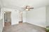 Bright and spacious living room with plush carpeting and a ceiling fan, offering a warm and inviting atmosphere.