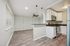 Modern open-plan living area with sleek kitchen, stylish pendant lighting, and chic brick accent wall.