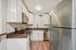 Modern kitchen featuring sleek stainless steel appliances, vibrant countertops, and elegant white cabinetry.
