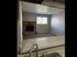 Inviting apartment entrance showcasing a cozy living area with a charming brick fireplace and abundant natural light.