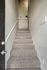 Chic, carpeted staircase with modern railing, leading to a cozy, well-lit nook with potted plants.