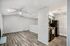 Contemporary open floor plan with sleek wooden flooring, a spacious living area, and a modern kitchen featuring black appliances.