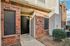 Inviting apartment entrance with classic red brick fa&ccedil;ade and modern black door, perfect blend of charm and style.