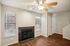 Inviting living room with rich hardwood floors, elegant ceiling fan, and a cozy fireplace perfect for relaxing evenings.
