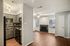 Contemporary apartment featuring a modern kitchen with sleek cabinetry and a cozy living area with a stylish fireplace and ceiling fan.