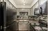 Modern kitchen with sleek black appliances, stylish tiled backsplash, and elegant black countertops.