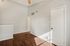 Inviting room with rich wood flooring, neutral walls, and ample natural light streaming in.