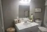 Inviting bathroom with modern fixtures, featuring a sleek white vanity, cozy decor, and ambient lighting for a spa-like experience.