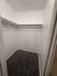 Spacious walk-in closet with plush carpet and ample shelving space, ideal for organizing your wardrobe in style.