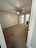 Inviting carpeted bedroom with sleek ceiling fan, leading to a bright walk-in closet and modern bathroom.