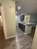 Inviting apartment interior featuring modern flooring, a sleek kitchen with dark cabinetry, and recessed lighting for a cozy atmosphere.