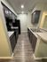 Sleek modern kitchen with elegant dark cabinets, polished countertops, and stylish wood flooring, creating a chic and inviting culinary space.