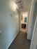Inviting hallway with soft carpeting leading to a modern bathroom with stylish lighting.