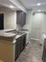 Modern kitchen with sleek gray cabinetry, textured walls, and elegant gray countertops, enhancing the stylish ambiance.