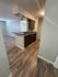 Modern apartment boasting an open kitchen with sleek countertops, stylish cabinets, and elegant wood flooring.